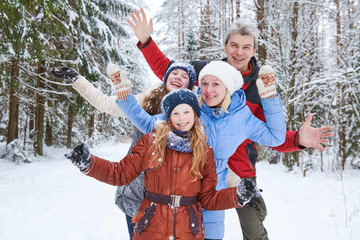 happy smiling family in winter snowy forest