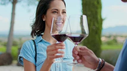 Romantic couple, woman toasting and smiling with red wine at sunset warm light. Friends italian trip in Umbria.4k slow motion