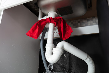 Red Napkin Tied Under The Leakage Sink Pipe