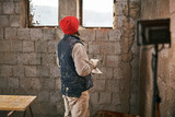 Real construction worker making a wall inside the new house.