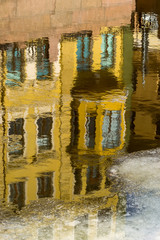 Reflection of houses on the waterfront in the water of the river