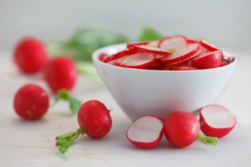 Sliced red radish in white bowl. Healthy radish salad.