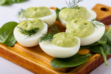 Deviled eggs with avocado and spinach on festive Easter table