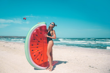 Model with watermelon lilo at the beach