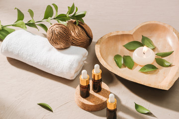 Burning candle in water. Spa setting with salt and pebbles on wooden background