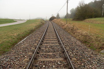 Schienenstrang in der nebligen Landschaft