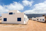 Empty street with sand and white houses in Caleta de Sebo on the island La Graciosa