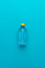 plastic water bottle with yellow cap on the blue background