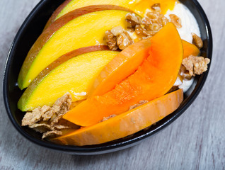 Sweet pumpkin and mango and whipped cream with  oat-flakes  at plate