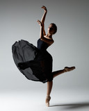 Young beautiful ballerina is posing in studio