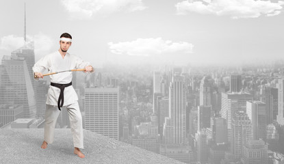 Young karate trainer doing karate tricks on the top of a metropolitan city
