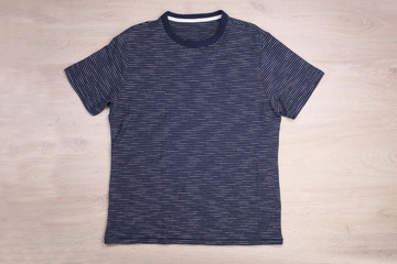Blue navy striped white t-shirt on wooden background