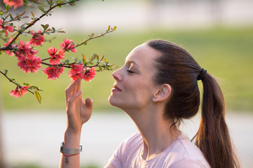 Girl smelling blooming tree