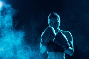 Front view of serious boxer in boxing gloves looking at camera