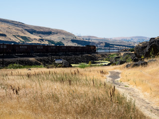 Dallesport, WA, USA - July 24, 2017: Freight train running along Columbia River Gorge in eastern Washington State