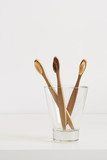 Bamboo toothbrushes with natural bristles in glass in Scandinavian style bathroom