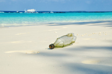 Plastic bottle on sand beach. Plastic pollution of nature. Ecology and environment concept. Waste emission to ocean