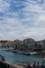 Boats and yachts at harbour with residential houses at waterfront