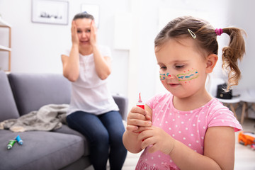 Shocked Mother Looking At Her Daughter Painting Face