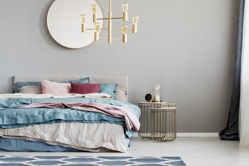 Fashionable bedroom interior with king size bed with blue, pink and beige bedding