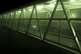Footbridge overpass with green light going over a main road highway on a foggy night
