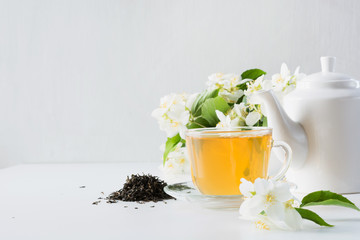 Cup of green jasmin tea white jasmine flowers, teapot. Teatime. Copy space.