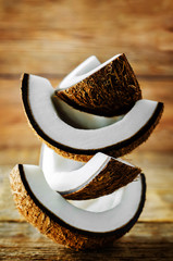 Coconut with slices on a wood background