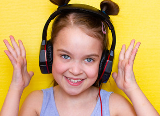 Cute little girl listening music in headphones