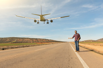 Man hitchhiking and airplane landing on the road