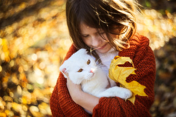 girl with flowing hair with a white cat, autumn