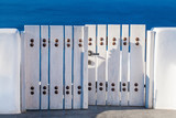 White and blue details. White wooden gate and sea, Santorini, Greece
