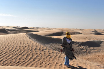 Woman with a covered face in the desert.