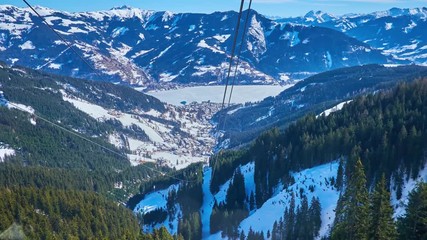 ZELL AM SEE, AUSTRIA - FEBRUARY 28, 2019: Schmittenhohenbahn cable car breath-taking journey with a view on Alpine snowy slopes, pistes, forests and frozen Zeller see, on February 28 in Zell Am See