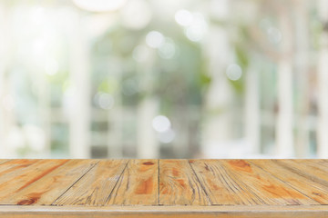 Empty wood table top and blurred of interior room with window view from green tree garden background background - can used for display or montage your products.