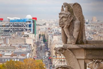 Mythical creature gargoyle on the roof of Cathedral Notre Dame de Paris. View from the tower.