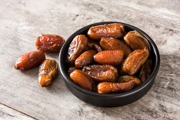 Dates in black bowl on wooden table