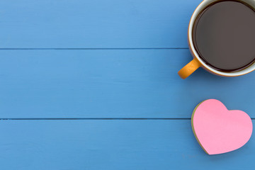 Coffee cup and pink love heart top view on blue wood table minimal background
