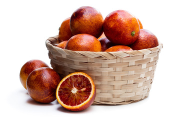 Ripe red oranges in wicker basket isolated on white