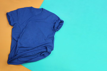 Wrinkled blue mockup t-shirt on orange and blue pastel background