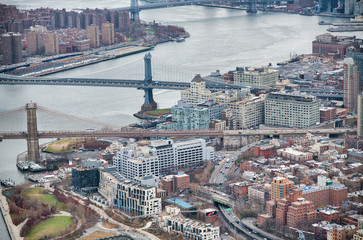 New York City from helicopter point of view. Brooklyn and Manhattan Bridges with Manhattan skyscrapers on a cloudy day