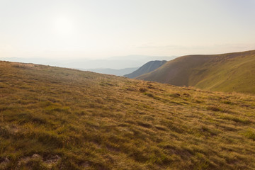 mountain plateau with grass at the sunset