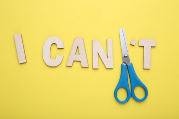 Text I can't and scissors on yellow background