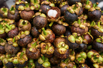Ripe mangosteens lying on each other outdoors