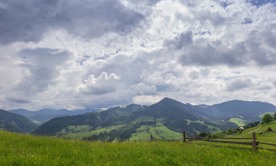 Mountain ranges with fenced hayfields on a foreground
