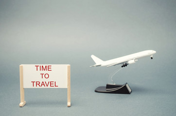 A poster with the words Time to travel and a miniature airplane. The concept of planning a summer or winter vacation. Family rest. Hot tours. Available offers. Aircraft. Plane