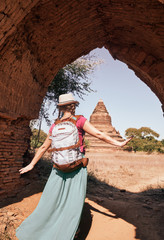 woman traveller with backpack walking through the Old Bagan looking the ancient ruins. Myanmar.
