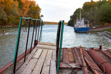 Gangway on the pontoon on the background of the river with the ship