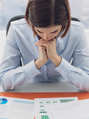 Focused businesswoman checking financial reports and thinking