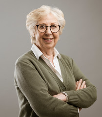 Happy senior lady posing on gray background