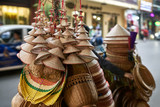 Street seller with asian conical wooden hats and baskets